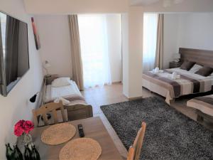 uma sala de estar com duas camas e uma mesa em Planeta Apartment Mielno em Mielno