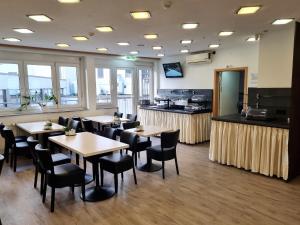 a restaurant with tables and chairs and a kitchen at Adler Hotel Frankfurt in Frankfurt