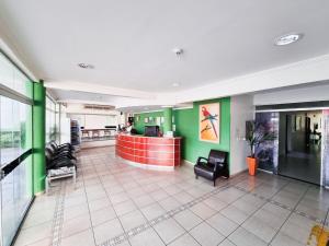 a lobby of a hospital with green walls and chairs at Cerrados Park Hotel in Várzea Grande