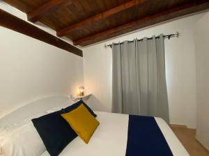 a bedroom with a white bed with a yellow pillow at Casa Vacanza Porta Smeralda in Olbia