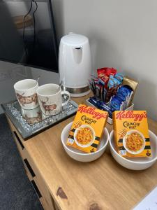 a table with two bowls of breakfast cereals and cups at Attic views in Caol