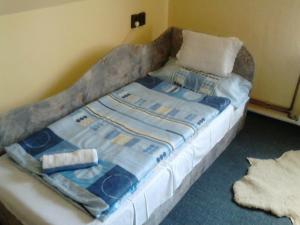 a bed in a room with a blanket on it at Lilla Apartman in Sárvár