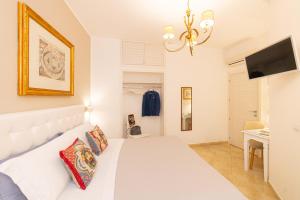 Un dormitorio con una cama blanca y una lámpara de araña. en Dionisio House, en Taormina