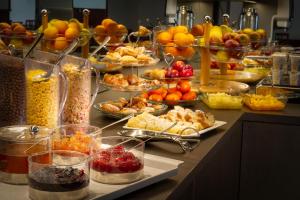 a counter filled with lots of different types of food at Hotel Harmony in Prague