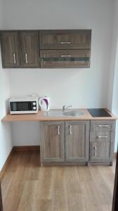 a kitchen counter with a sink and a microwave at Willa Bryza Rewa in Rewa