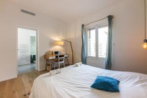 une chambre avec un lit blanc et une fenêtre dans l'établissement Bord de mer, magnifique appartement de 150m2 avec jardin, à Marseille