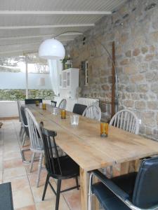 comedor con mesa de madera y sillas en Les Grangeonnes, gîtes nature, piscine, sauna pour accueil familiale ou de groupe en Saint-Basile