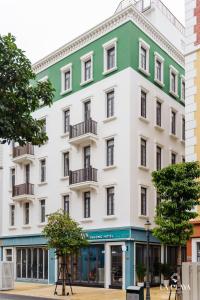a white and green building on a city street at La Playa Ha Long Hotel in Ha Long