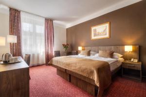 a hotel room with a large bed and a window at Hotel Harmony in Prague