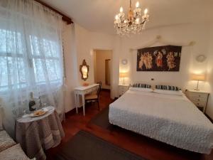 a bedroom with a white bed and a chandelier at Luxury House B&B in Bassano del Grappa
