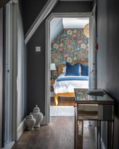 a bedroom with a bed with a floral wall at The White Horse in Faversham