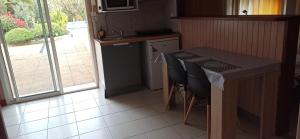 a kitchen with a counter and a table with chairs at Les Caraïbes in Peyrehorade