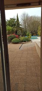 a view of a courtyard through a glass door at Les Caraïbes in Peyrehorade