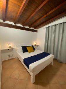 a bedroom with a white bed with blue and yellow pillows at Casa Vacanza Porta Smeralda in Olbia