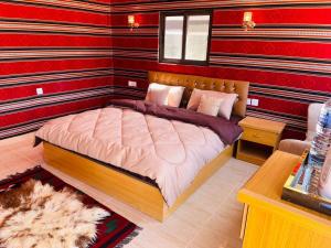 ein Schlafzimmer mit einem Bett in einem Zimmer mit roten Wänden in der Unterkunft Rum Magic Nights in Wadi Rum