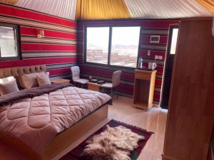 a bedroom with a bed and a desk and a window at Rum Magic Nights in Wadi Rum