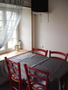a dining room table with four chairs and a window at Les Lutins for 4 persons. near the sea. in Commes