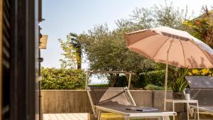 a chair and an umbrella on a patio at Lagoon in Sirmione