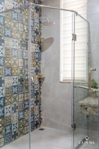 a bathroom with a shower with a glass door at La Playa Ha Long Hotel in Ha Long +32 photos