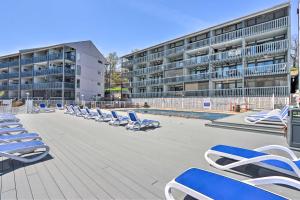 欧塞奇比奇Lake of the Ozarks Views Osage Beach Condo!的建筑物前的一排蓝白色休闲椅