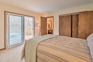 Schlafzimmer mit einem Bett und einer Glasschiebetür in der Unterkunft Secluded Poconos Home with Decks about 1 Mi to Lake in Jim Thorpe