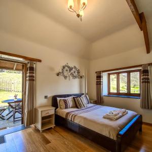 een slaapkamer met een bed, een tafel en een raam bij Ta Mill Cottages & Lodges - Olde Granary in Launceston