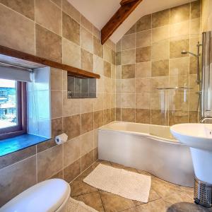 een badkamer met een bad, een toilet en een wastafel bij Ta Mill Cottages & Lodges - Olde Granary in Launceston