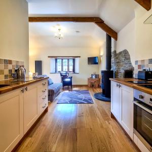 een keuken en een woonkamer met een fornuis bij Ta Mill Cottages & Lodges - Olde Granary in Launceston