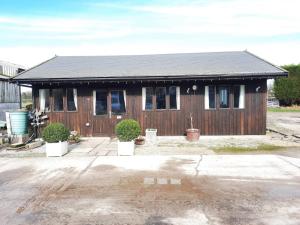 a small house with a black roof at One bedroom lodge in the countryside in Congleton