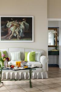 a living room with a couch and a painting at Hotel Caesar Augustus in Anacapri