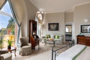 a bedroom with a bed and a living room at Hotel Caesar Augustus in Anacapri