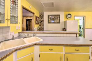 a yellow kitchen with a sink and a refrigerator at Cozy Home with Hot Tub Half Mi to Salmon River! in Salmon +29 photos