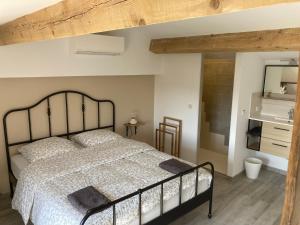 a bedroom with a large bed and a bathroom at Cottage les Marjoris Tanneron in Tanneron