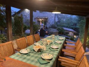 einen langen Tisch mit Tellern und Gläsern auf einer Terrasse in der Unterkunft “SPArisio” CASA IN SASSO CON PISCINA E CAMPO DA TENNIS in Lama