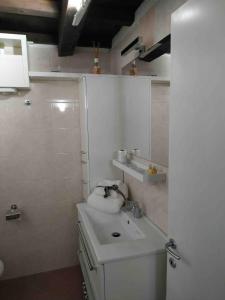 a white bathroom with a sink and a mirror at CasaLina in Comacchio +26 photos