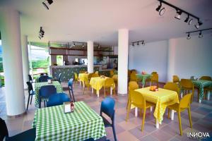 a restaurant with yellow and green tables and chairs at Hotel Montserrat Plaza in Monterrey