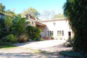 a large white house with a garden in front of it at Château Le Baudou in Coutras