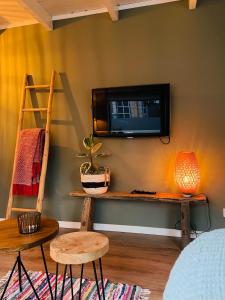 a living room with a tv on a wall at Beach House Parallel in Noordwijk