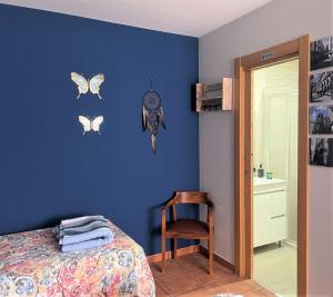 1 dormitorio con 1 cama y mariposas en la pared en B&B Puente de Órbigo, en Hospital de Órbigo