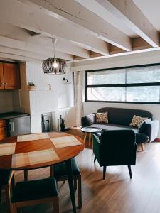 a living room with a couch and a table at Gîte cosy Lac de Payolle in Campan