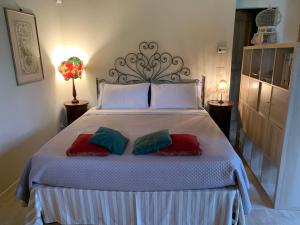 una camera da letto con un grande letto con tre cuscini di VIGORSO 41 COUNTRY HOUSE a Budrio