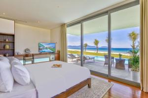 a bedroom with a bed and a view of the ocean at Luxury Dana Beach Resort & Spa in Danang