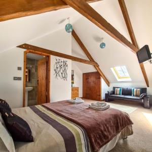 een slaapkamer met een groot bed op zolder bij Ta Mill Cottages & Lodges - Millers Cottage in Launceston