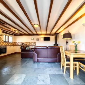 een woonkamer met een bank en een tafel bij Ta Mill Cottages & Lodges - Millers Cottage in Launceston
