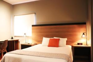 a hotel room with a bed with a red pillow at The Lot Boutique in Lima