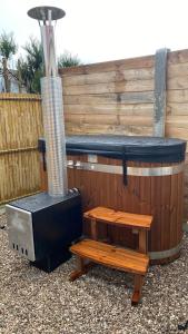 Wailly-BeaucampにあるCasa louisa chambre sauna et bain nordiqueのホットタブ、木製のフェンス付きのグリル