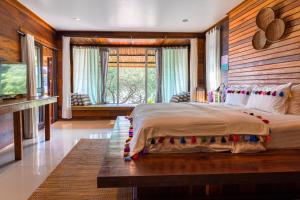 a bedroom with a large bed and a large window at Cookies Salad Resort in Salad Beach