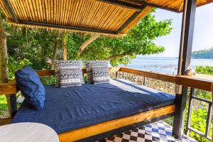 a bed in a pergola with a view of the ocean at Cookies Salad Resort in Salad Beach