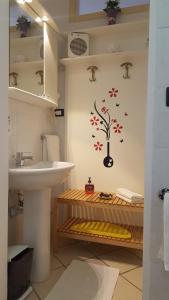 baño con lavabo y pegatina de árbol en la pared en Agriturismo I Pipetta, en Levanto