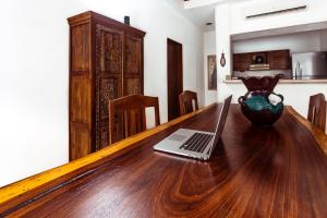a wooden table with a laptop on top of it at Fabiola Condo Hotel in Playa del Carmen